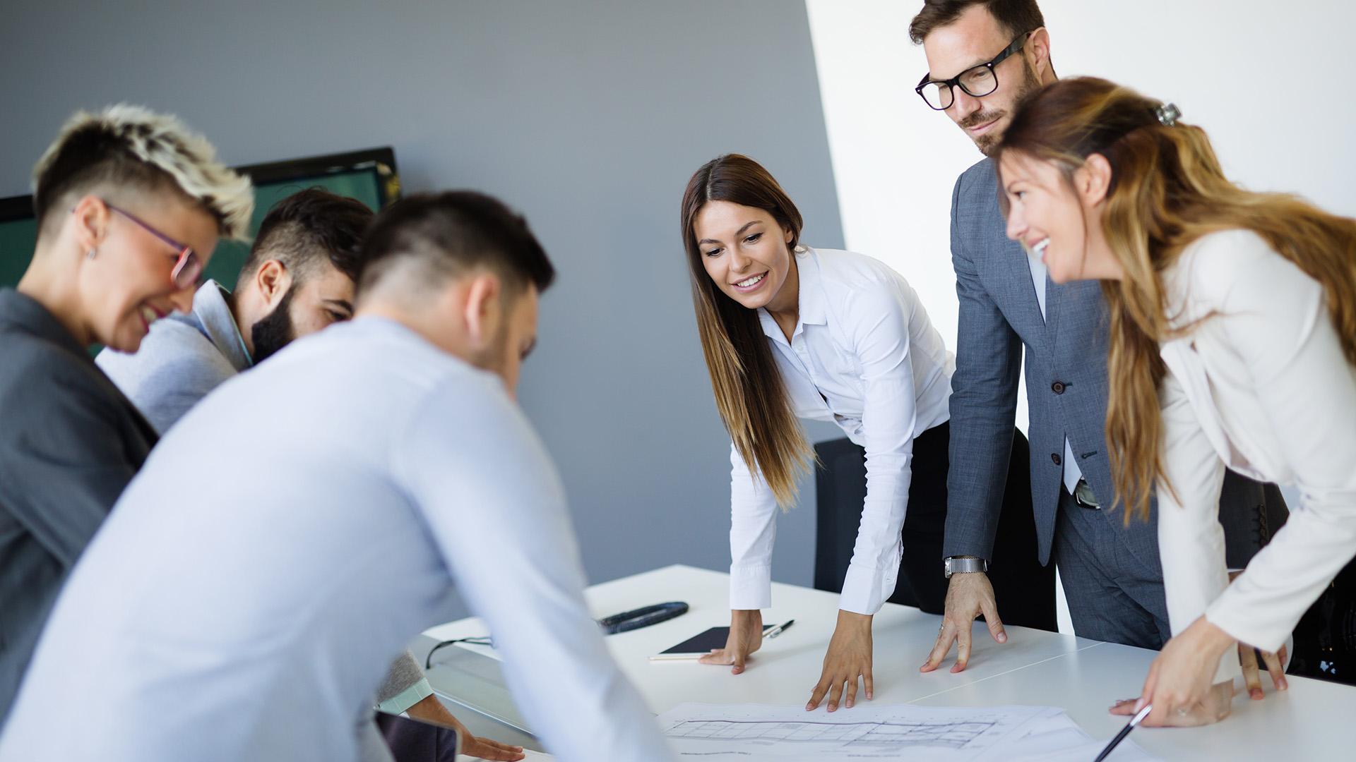 6 collegues standing at a table