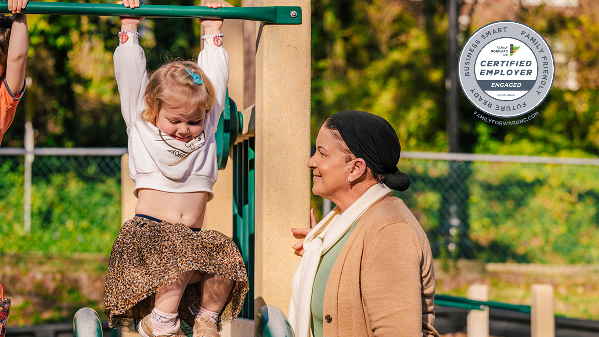 Picture of an elderly woman playing with a young child on a playground.